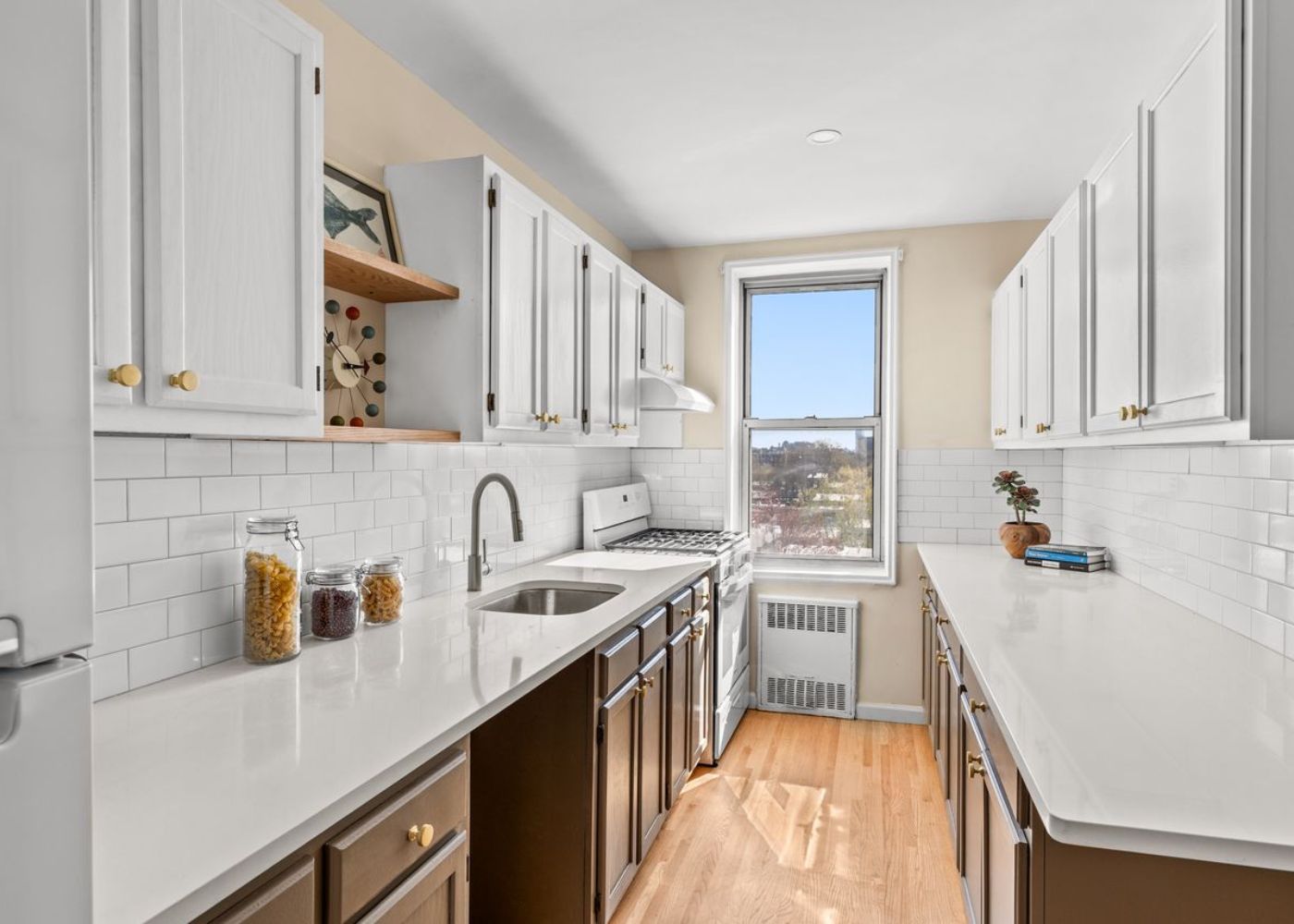 Bright Modern Galley Kitchen Design with White Cabinets and Natural Wood Flooring